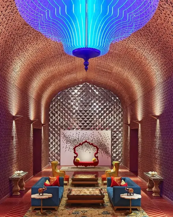 The lobby of Taj Devi Ratn, designed to be a modern palace. The vaulted ceiling with intricate latticework and the dramatic blue chandelier create a breathtaking welcome, setting the tone for a stay steeped in luxury and Rajasthani heritage.