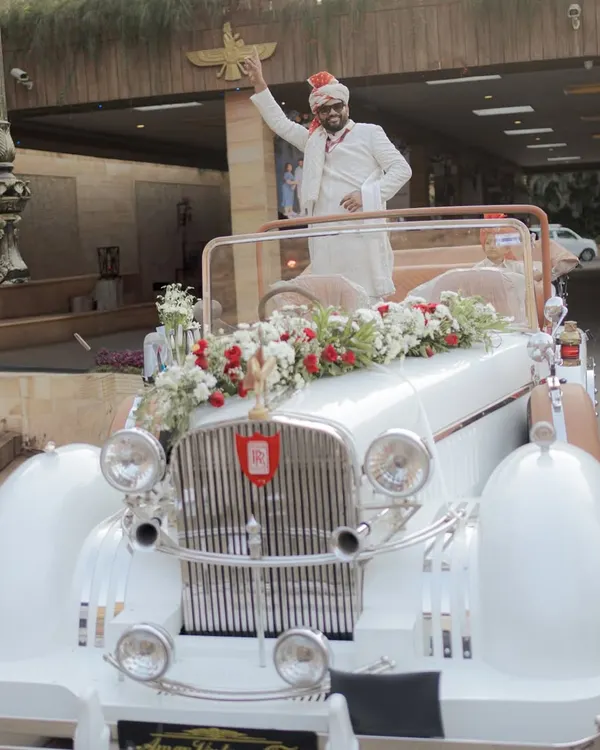 Making a statement with a grand entry in a vintage car. This is a classic and stylish way for the groom to arrive for his South Indian wedding.