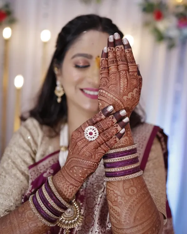 A radiant bride-to-be, her smile as bright as her stunning engagement mehendi.