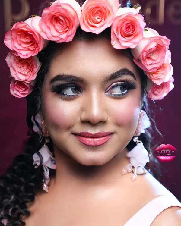 A close-up of a whimsical, fairy-tale look perfect for a Christian wedding or reception. The fresh rose flower crown and soft pink makeup create a romantic and dreamy vibe.