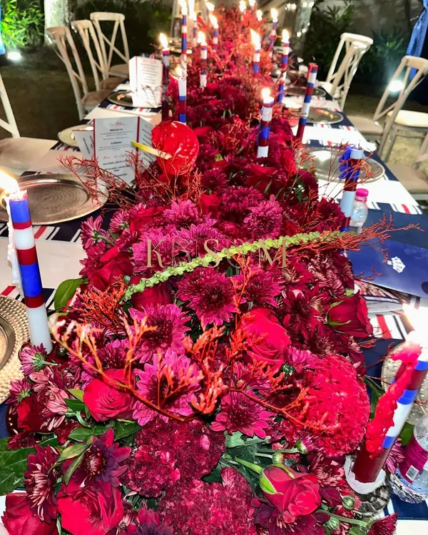 The brief for this event was a "London theme evening," so I went with a dramatic, monochromatic red tablescape. The dense floral runner, accented with custom candles, created a bold and sophisticated atmosphere for the dinner party.