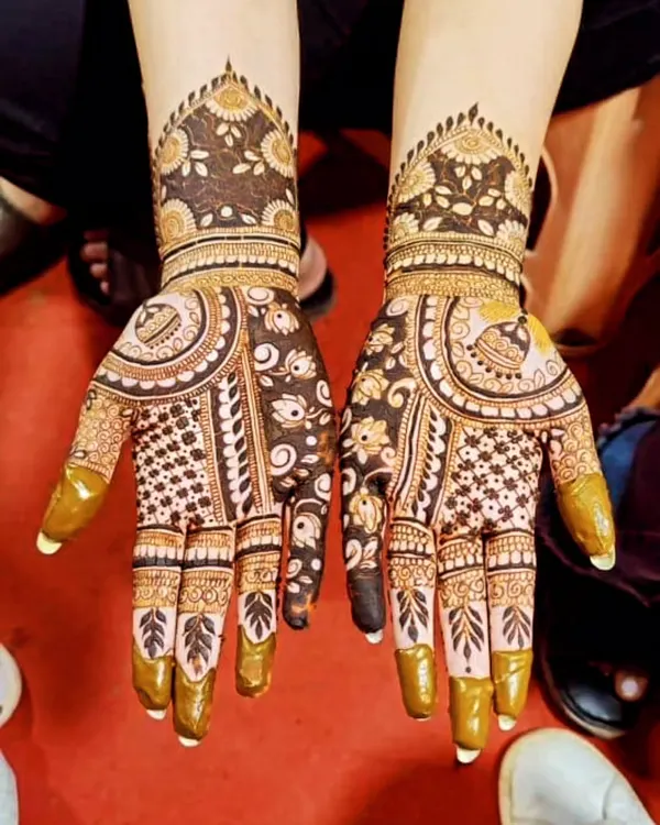 This is a beautiful example of using negative space in mehndi design. The skin left bare makes the intricate floral and paisley patterns pop, creating a look that is both rich and refreshingly modern.