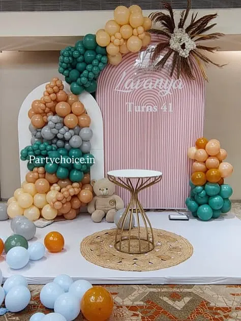 A closer look at the modern boho-chic decor for a 41st birthday, showing the texture of the balloons and the elegant cake table.