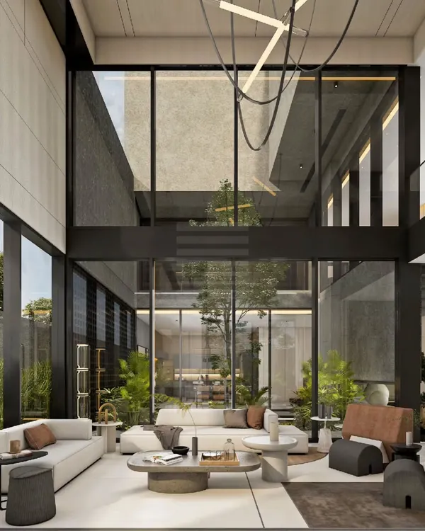 Another view of the 'House of Courtyards' living room, where soaring ceilings and floor-to-ceiling windows create a breathtaking sense of volume. The space is designed to feel both grand and intimately connected to the central green courtyard.