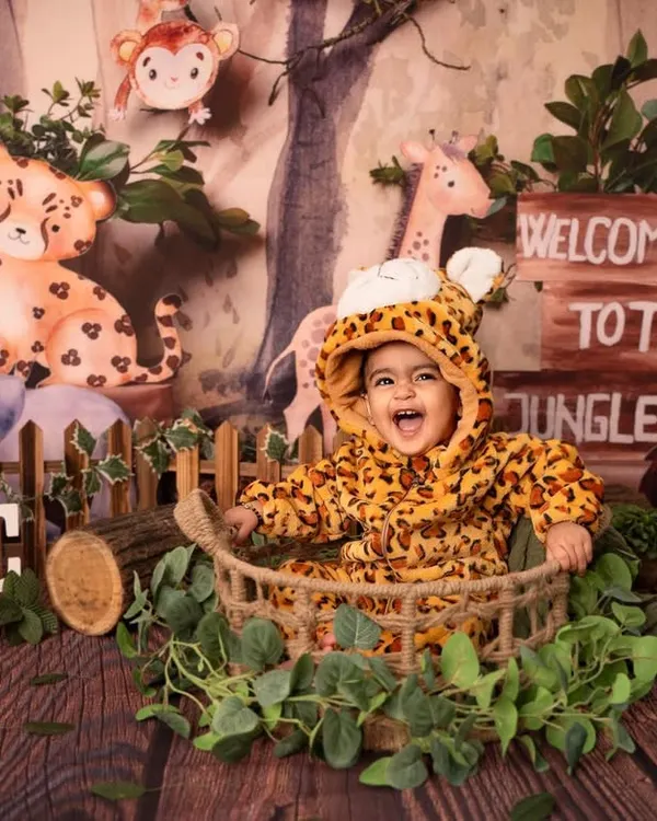 Welcome to the jungle! This little explorer is having a wild time in our jungle-themed first birthday setup, complete with adorable animal friends and lush greenery.