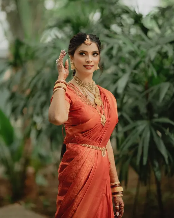 An elegant portrait of a South Indian bride. Her makeup is kept classic and clean to let the beautiful silk saree and traditional gold jewelry take center stage.