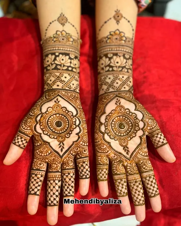 A designer creation featuring a beautiful mandala at the center of the palm. The look is completed with lotus motifs and checkerboard patterns on the fingers.