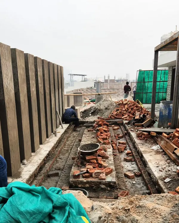 The initial construction phase of a terrace water body. This image shows the groundwork and brickwork being laid out before the finishing materials are applied.