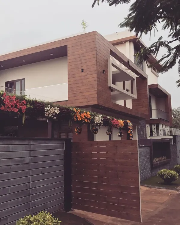 A bungalow we designed for an industrialist in Hubli, featuring a bold, modern aesthetic. The exterior is defined by strong horizontal lines, cantilevered structures, and a material palette of Fundermax panels and textured plaster.