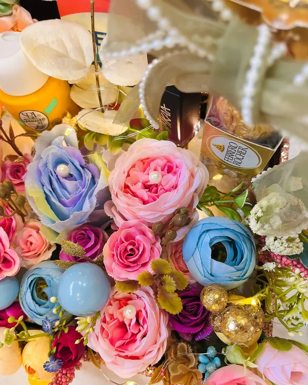 A close up of a vibrant and overflowing birthday hamper. This one was for a 30th birthday, featuring 30 beautiful blooms mixed with skincare goodies and chocolates.
