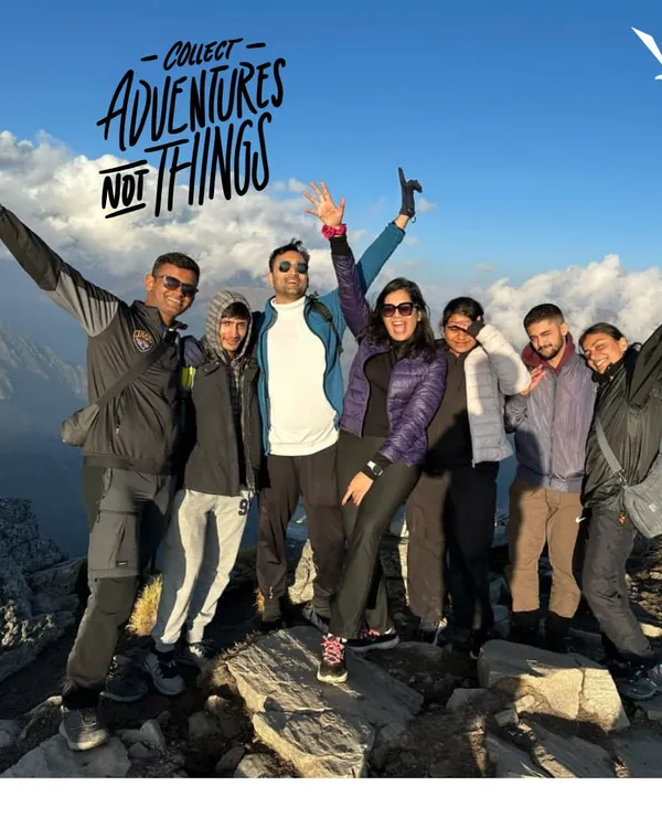 Collect adventures, not things. A happy group posing on a mountain top after a successful trek.