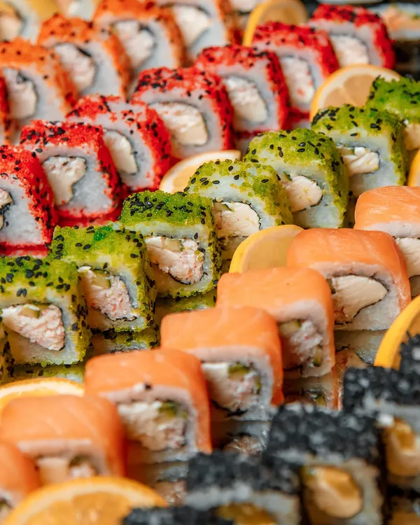 A colorful and enticing platter of assorted sushi rolls. We offer a wide variety of options, including salmon, tuna, and vegetarian rolls, all freshly prepared to provide a taste of Japanese culinary art.