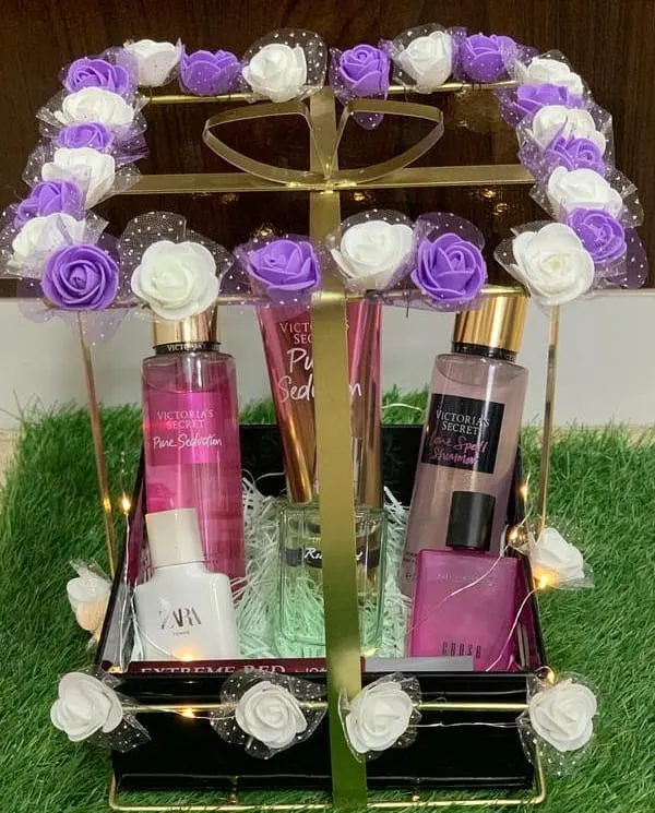 A stunning fragrance hamper designed for someone special. This elegant metal basket is filled with a collection of perfumes and body mists, and decorated with beautiful purple and white roses.