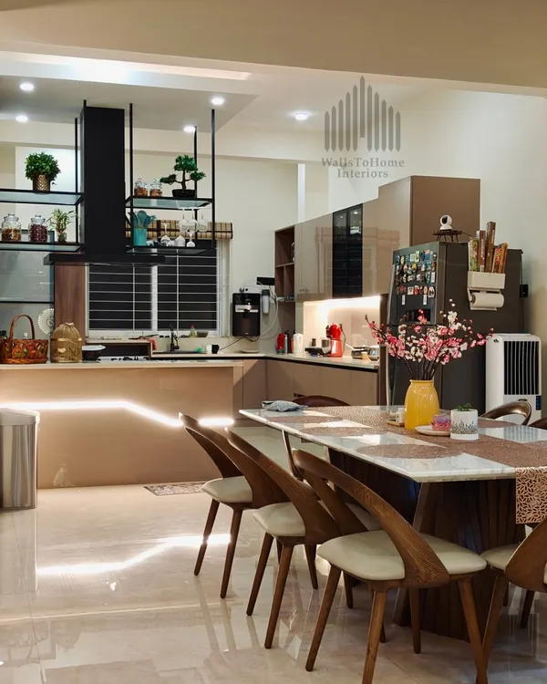 We believe the heart of the home is a space that radiates warmth and sophistication. This open-plan design seamlessly integrates a state-of-the-art modular kitchen with an elegant dining area, all brought together by ambient lighting. It’s a perfect example of how we craft spaces for both everyday living and grand entertaining.