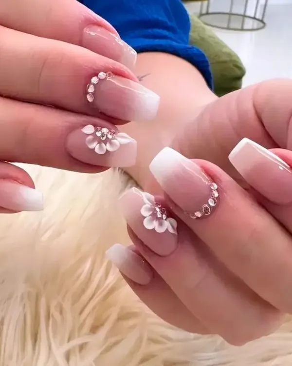 The quintessential bridal nail set. This design features a soft baby boomer ombré on square extensions, adorned with exquisite 3D white flowers and sparkling crystals.