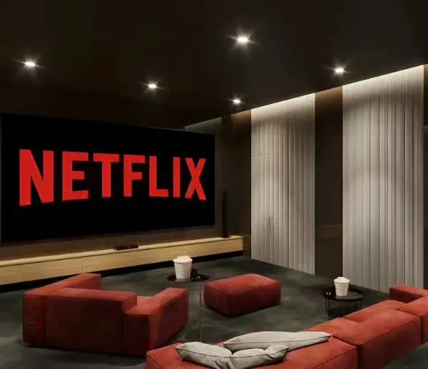 A simple yet effective home theater setup with a large screen and comfortable red sofas. The dark walls and minimalist design ensure an immersive, distraction-free viewing experience.