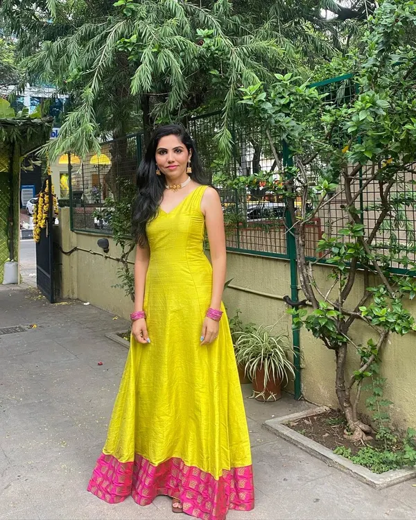 This full-length gown is crafted from vibrant yellow raw silk. I added a contrasting pink brocade border at the hem to give it a traditional touch while keeping the silhouette modern and clean.