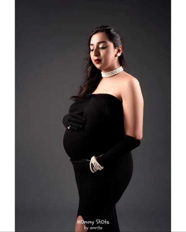 A different angle from the glamorous maternity shoot. The classic makeup with a bold red lip and soft waves creates a timeless and sophisticated portrait.