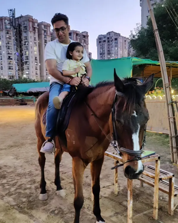 A father and his young daughter share a special moment on horseback. These sessions are a wonderful way to create lasting family memories.
