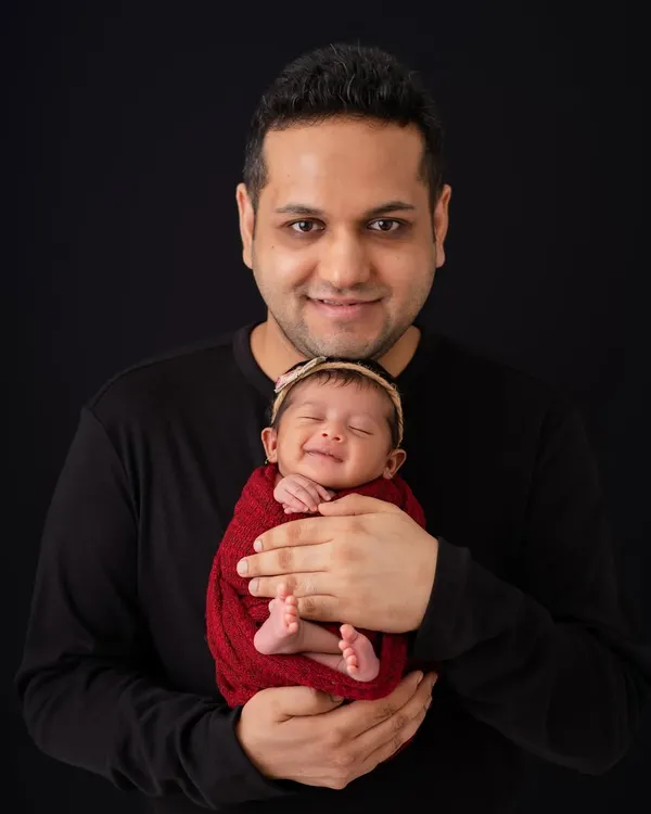 There is nothing more heartwarming than a newborn's smile. I have the patience to wait for these fleeting, magical expressions, creating a portrait this father will treasure forever.