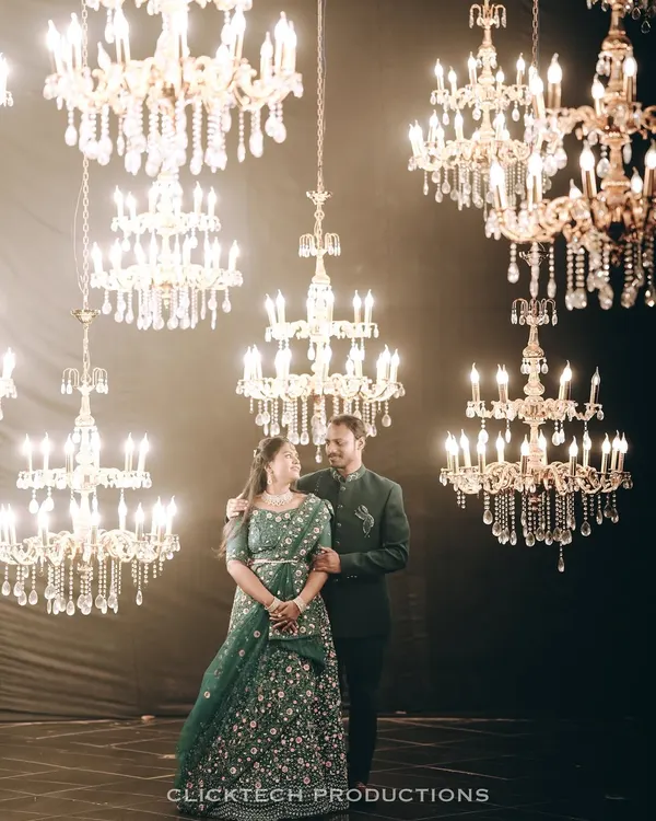 A couple stands together amidst a sea of glowing chandeliers. This pre-wedding shoot at Bengaluru Film City uses dramatic lighting to create a truly magical and luxurious feel.