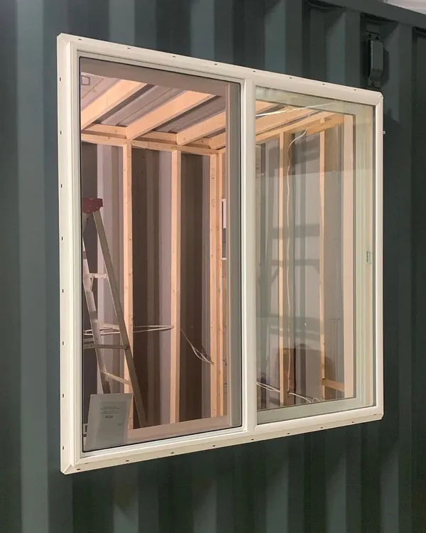 The transformation begins with precision. Here, we have installed a high-quality sliding window into a 20-foot container, part of its conversion into a music studio. You can see the internal wooden framing that will support insulation and interior walls.