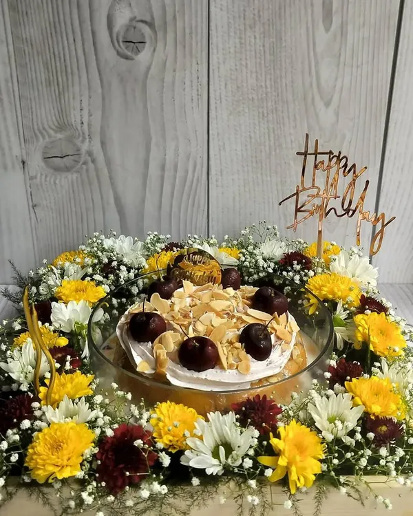 This Cherry Almond Tres Leches Floral Hamper is a perfect birthday centerpiece. The moist cake is topped with cherry whipped cream and toasted almonds, then surrounded by a beautiful arrangement of fresh flowers.