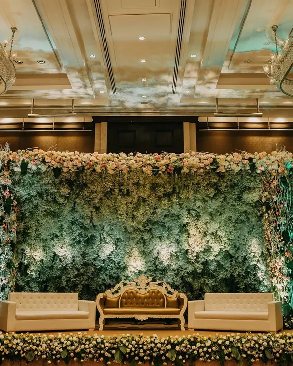 This reception stage at the St. Regis Mumbai uses a dense wall of gypsophila to create a lush, textured backdrop. The design elevates a simple filler flower into a primary element, resulting in a sophisticated and ethereal setting for welcoming guests.