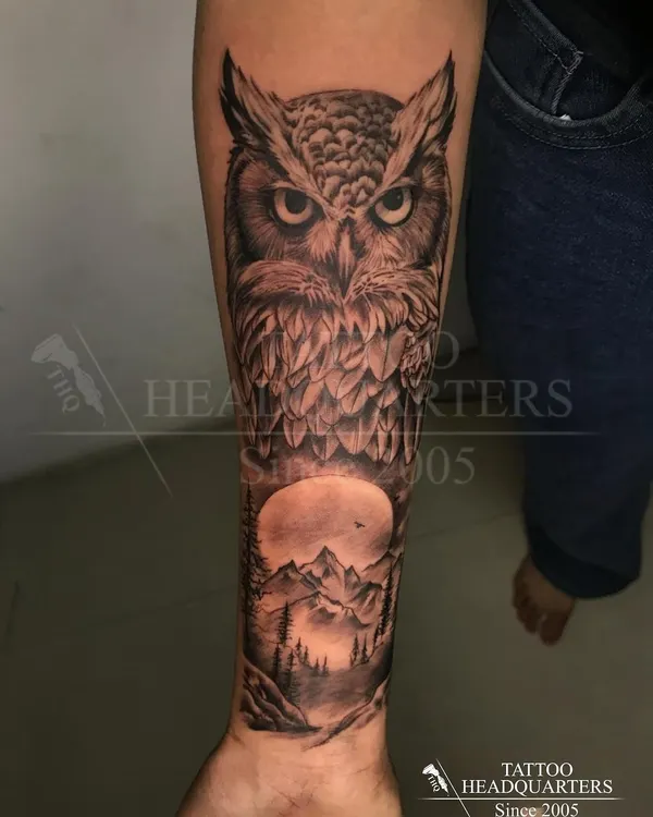 A stunning forearm sleeve featuring a realistic owl against a full moon and a forest landscape. A complete nature scene in one piece.