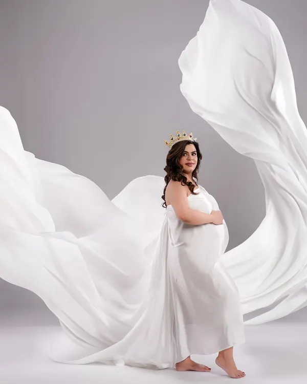 A powerful and graceful portrait of a mother-to-be, crowned and draped in flowing white fabric. This shot is all about celebrating the queen you are.