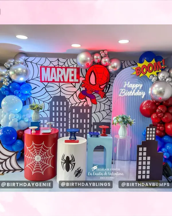 A spectacular Marvel and Spider-Man themed party, featuring a city skyline backdrop, comic book web patterns, and bold red and blue balloon garlands.