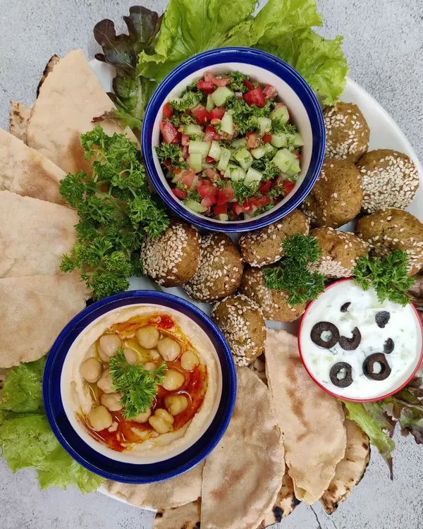 Our complete vegetarian Mezze Platter, perfect for sharing. This board features our handmade falafel, soft pita bread, classic hummus, creamy tzatziki, and a fresh tabbouleh salad, all made from scratch in our kitchen.