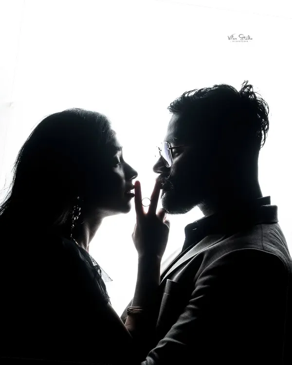 A powerful and artistic silhouette. This high-contrast, black and white style focuses on the form and connection of the couple, creating a dramatic and modern portrait.