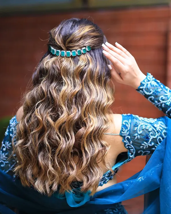 Beautiful, bouncy curls with a lovely shine. This half updo is accented with an elegant green hair clip, perfect for a reception or cocktail event.