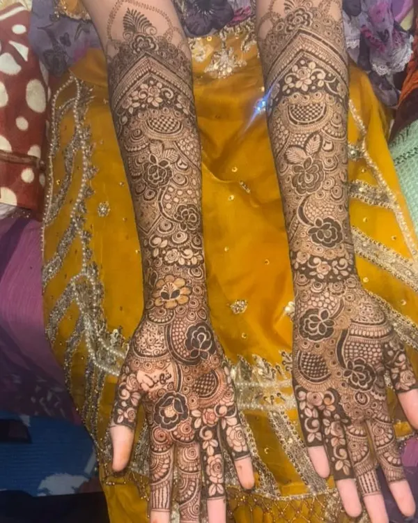 A classic full-arm bridal design with dense, interwoven patterns. Every inch is filled with detail, from the fingertips to the elbow, featuring floral vines and traditional Indian mehendi art.