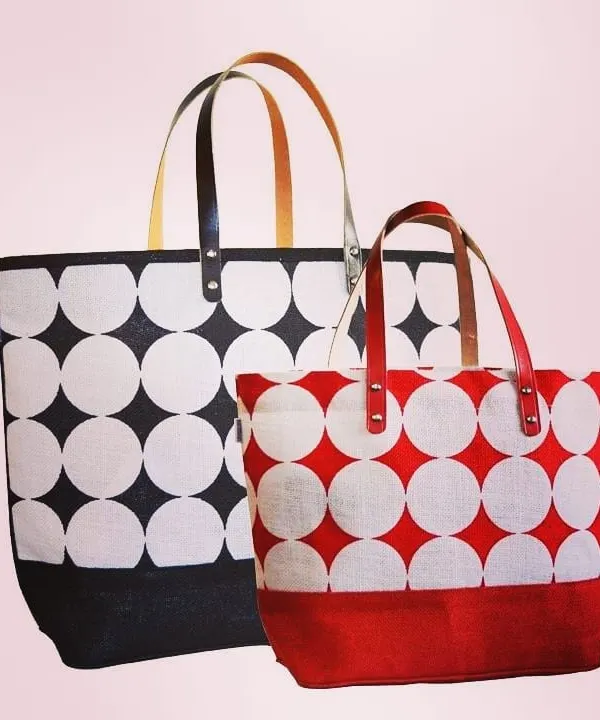 We manufacture premium jute tote bags in various sizes and designs, perfect for retail or high-end promotional use. This image displays two options from a single collection, featuring a bold geometric print in different color schemes and durable, stylish faux-leather handles.