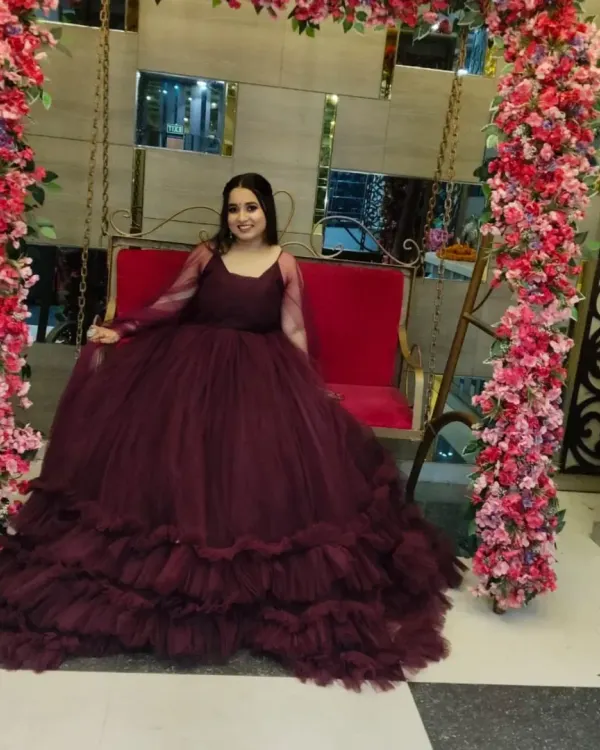 A client looking absolutely stunning in a wine-colored ruffled ball gown. This gown is perfect for making a grand entrance at a reception or sangeet.