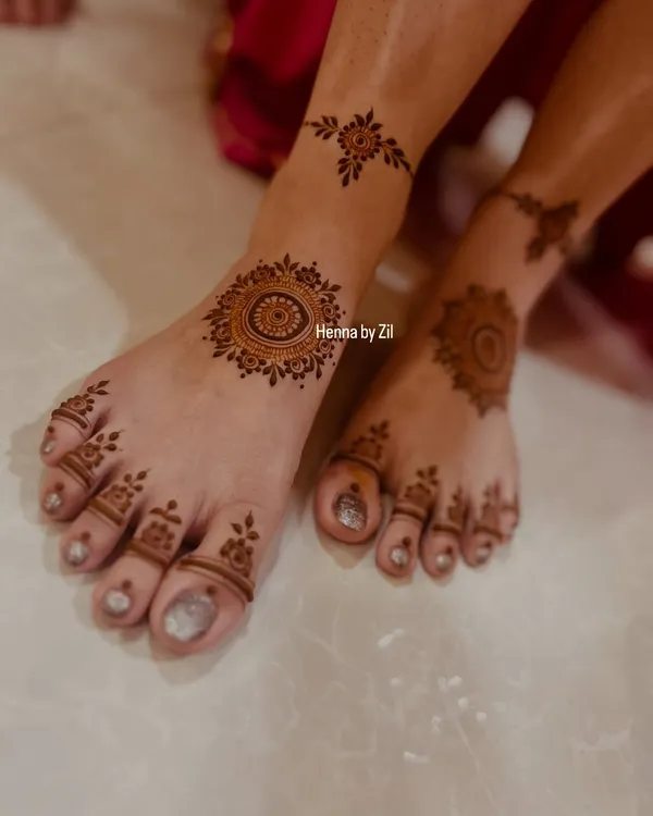 A simple yet beautiful foot mehendi design. This style features a central mandala on the top of the foot with delicate patterns on the toes and a small anklet band, perfect for a bridesmaid or guest.