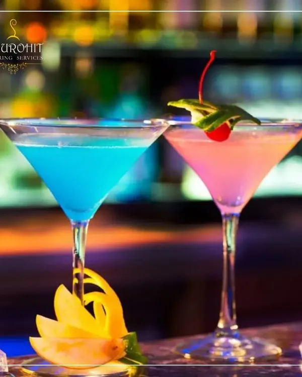 I believe a drink should be a centerpiece of your celebration. Here, two of my custom creations, a vibrant Blue Lagoon and a delicate pink mocktail, are served in classic martini glasses. The presentation, with artistic garnishes like a carved starfruit peel and a fresh cherry, reflects my commitment to making every detail perfect.