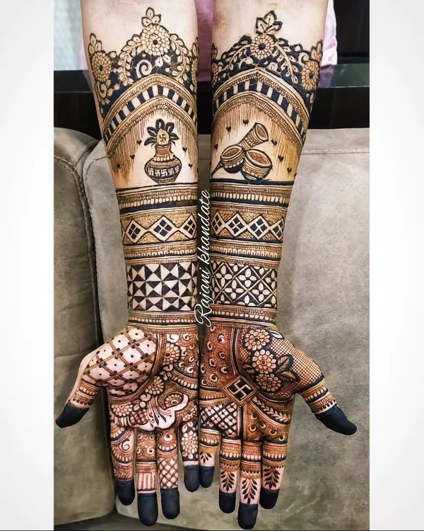 Mehndi for the groom. This design features full-arm coverage with traditional motifs like the 'kalash' and 'dhol', combined with modern geometric bands for a stylish and masculine look.