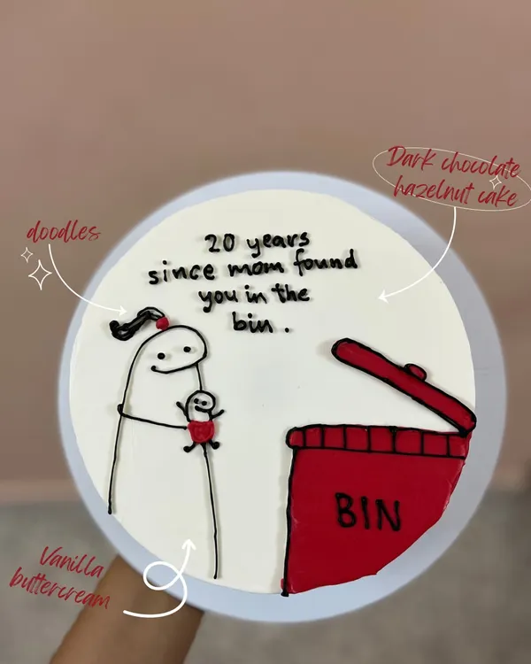 A funny and relatable cake for a sibling. This design features a Flork meme doodle with the text "20 years since mom found you in the bin," made on a dark chocolate hazelnut cake.