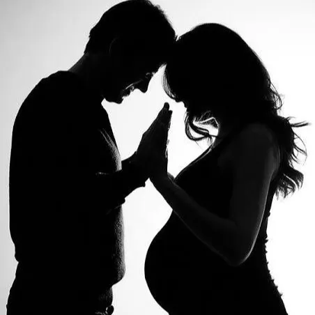 An artistic black and white silhouette of an expecting couple, capturing an intimate moment before their new arrival. This style of creative maternity photography focuses on emotion and connection.