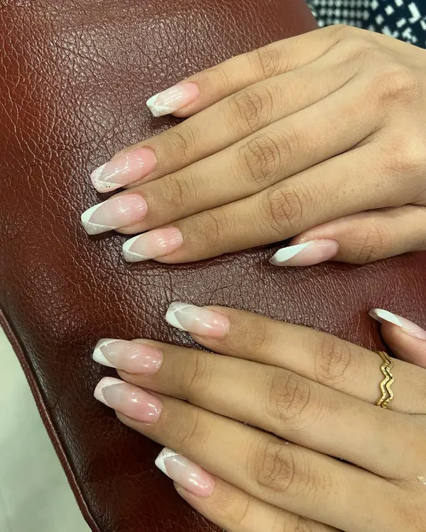 A perfect example of a modern French manicure. This design uses clean, geometric white lines on a natural pink base for a fresh and stylish look.
