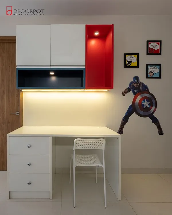 A study space fit for a superhero. This design features a clean white desk with drawers, overhead cabinets in red and blue, and a Captain America decal for a fun, personalized touch.