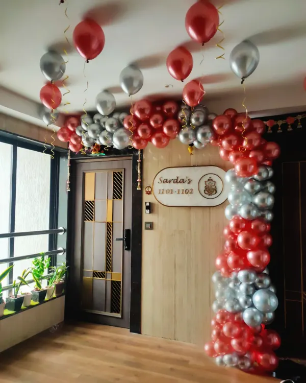 A simple and elegant balloon arch for a house entrance. This decoration in red and silver chrome balloons is a great way to welcome guests for a birthday or anniversary celebration at home.