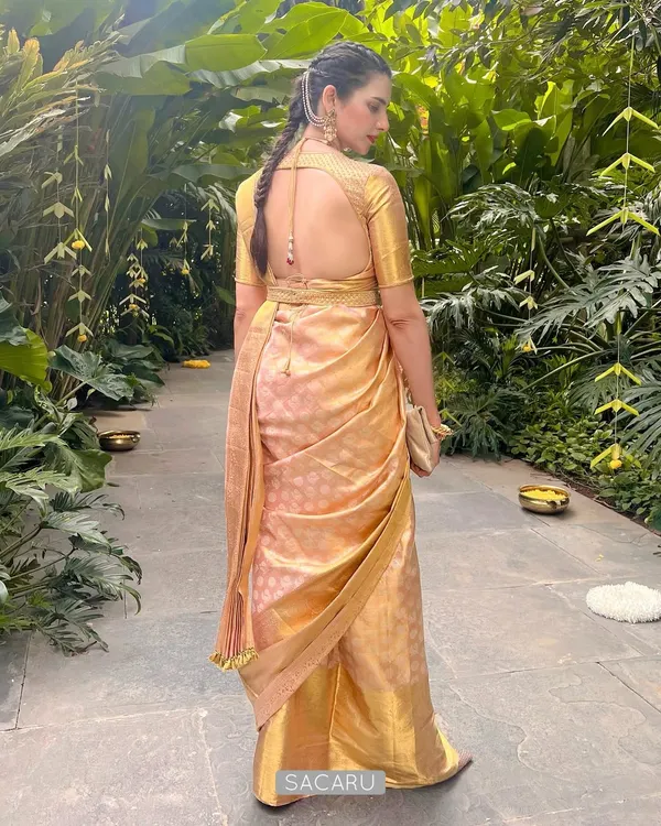 This is the essence of our design philosophy. We created a custom backless blouse with monotone gold embroidery and a matching belt to perfectly complement our client Madhuri's stunning gold Kanjeevaram saree, ensuring a look of timeless grace.