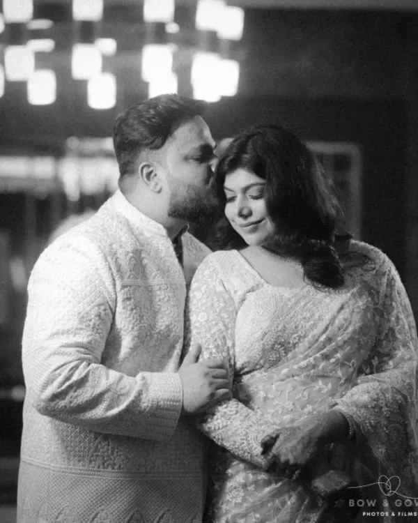 A tender moment from a Roka ceremony, captured in classic black and white. The groom's gentle kiss on her forehead and their close embrace speak volumes about their love story.