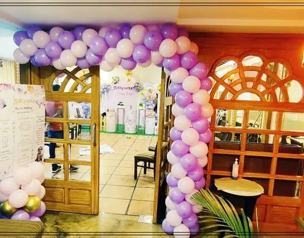 A beautiful balloon archway in purple and white creates an inviting entrance for a butterfly-themed birthday party. It sets the tone for the celebration right from the door.