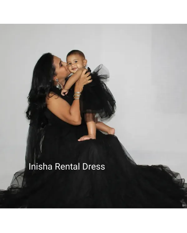 A beautiful moment between a mother and her daughter, both dressed in our matching black outfits. The mother's flowing netted gown and the baby's cute tutu are available for rent together.