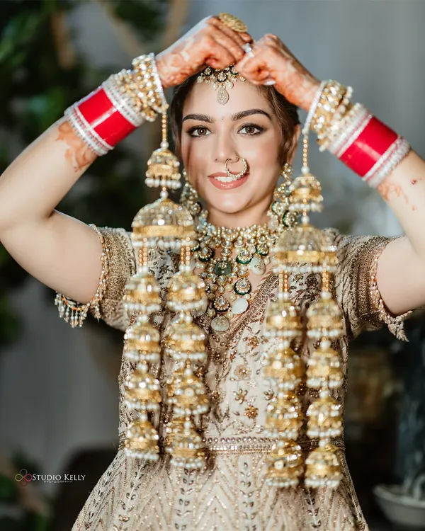 A classic bridal shot of a Sikh bride proudly showing off her beautiful 'kalire', a symbol of her new journey.